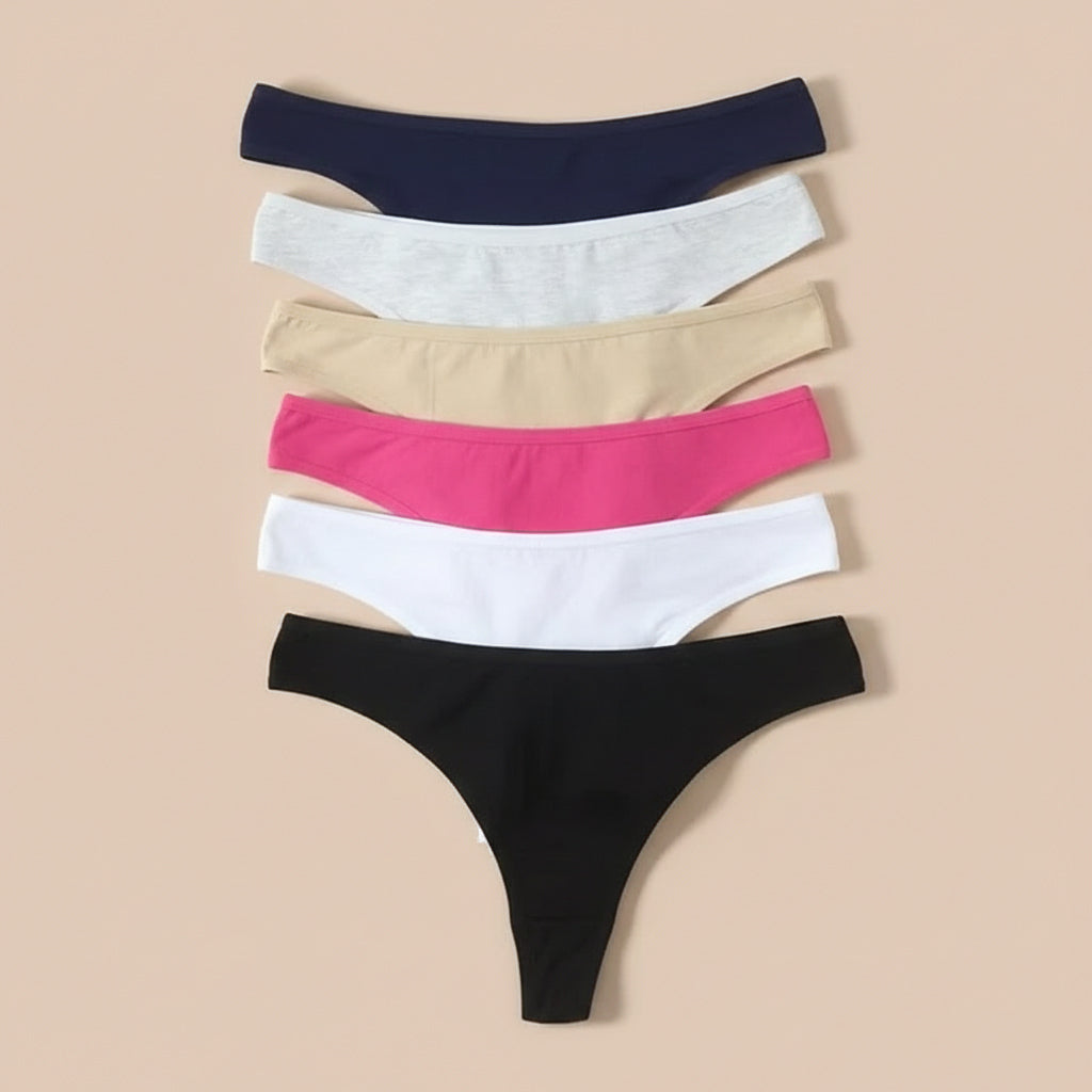 Set of five pairs of underwear in black, white, pink, beige, and navy on a beige background.