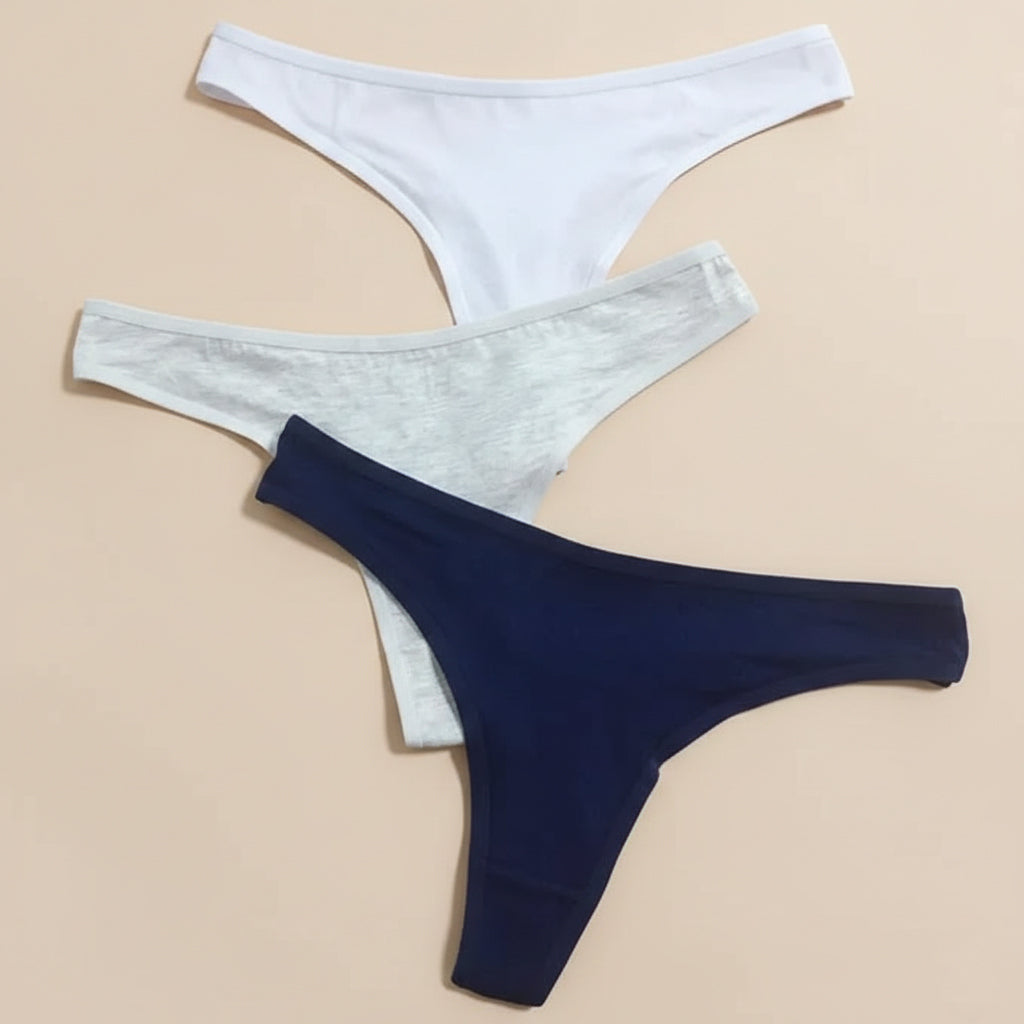 Three pairs of men's underwear in white, gray, and navy on a beige background