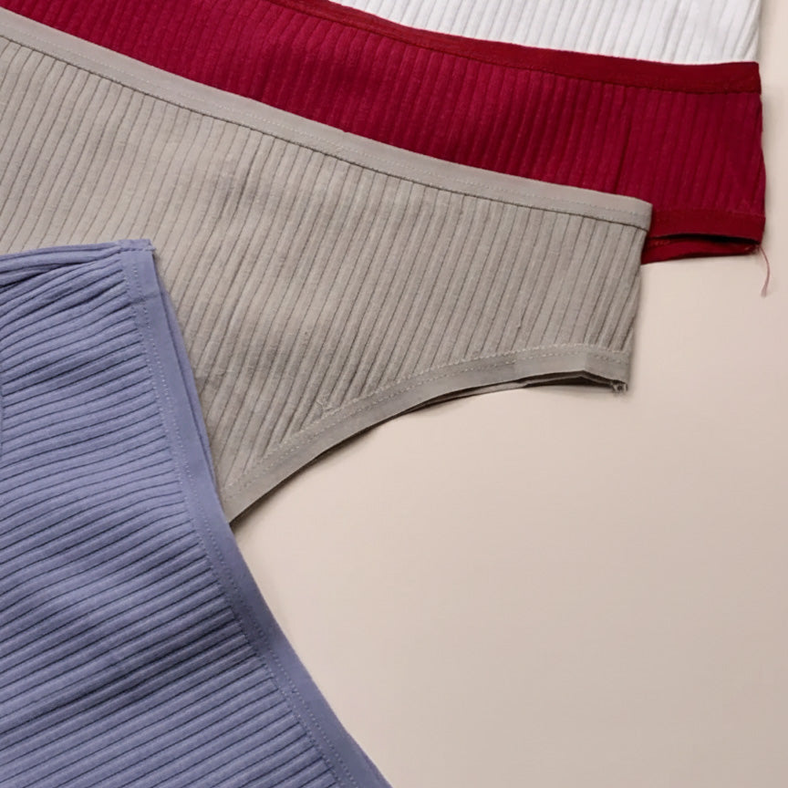 Close-up of ribbed knit fabric in gray, red, and blue on a beige background